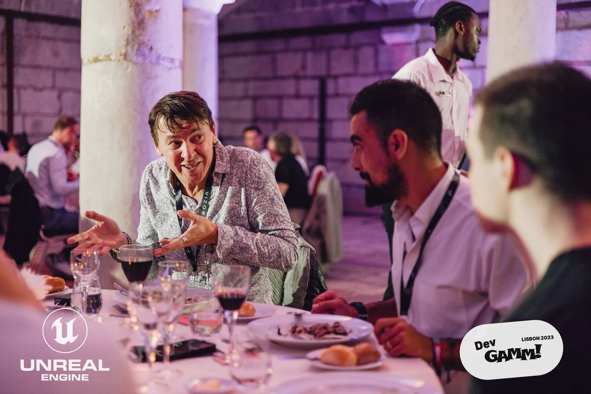 David Olim talking with game developers around a dinner table