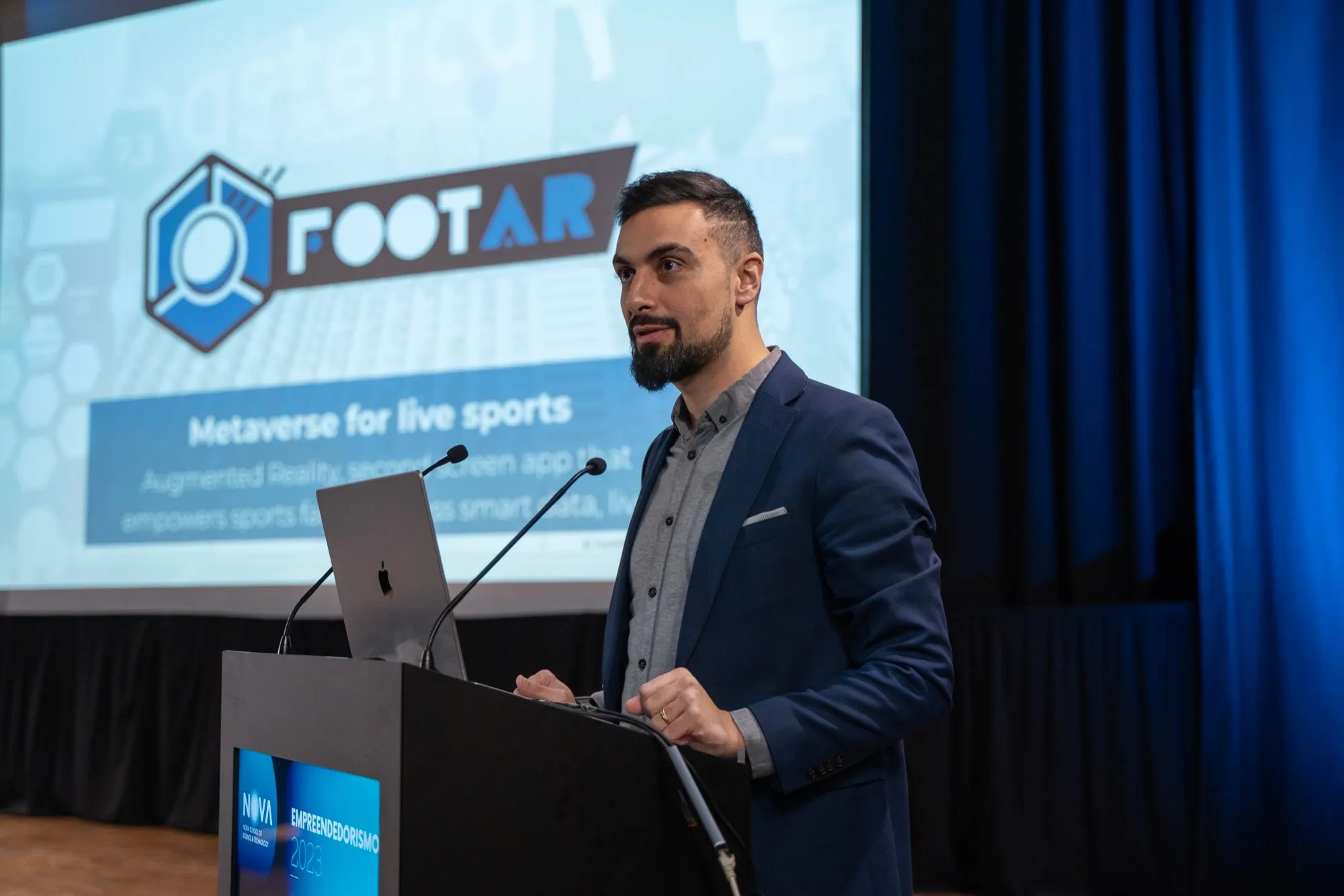 David Olim at a lectern presenting FootAR, with the FootAR logo on the screen behind him