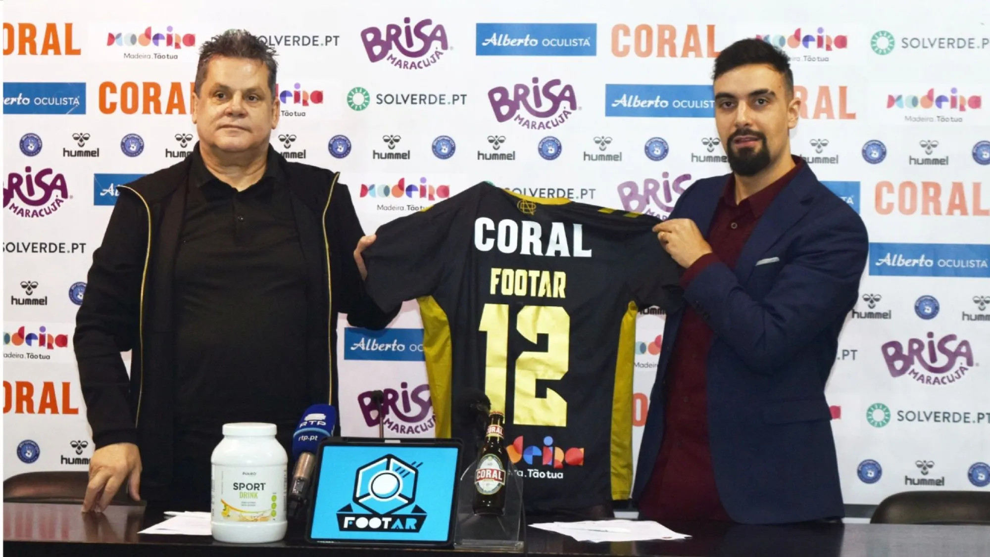 David Olim and a CD Nacional representative holding a CD Nacional shirt with FootAR 12 at a press conference