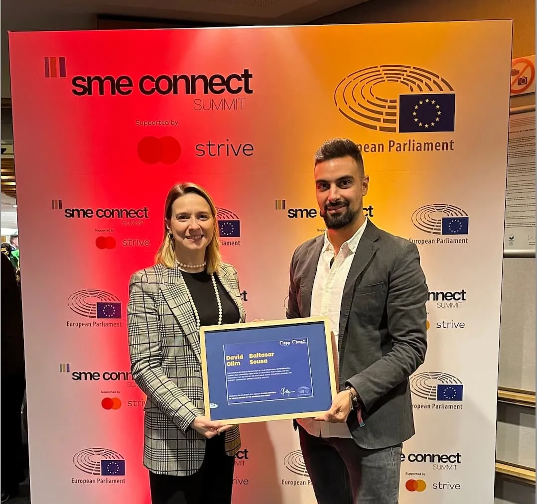 The SME Europe award certificate for David Olim and Baltasar Sousa, held up at the SME Connect Summit