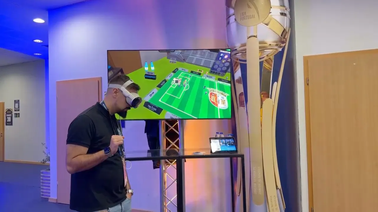 A visitor in Apple Vision Pro at the Allianz Cup Final Four, beside the trophy, with the 3D match mirrored on a screen