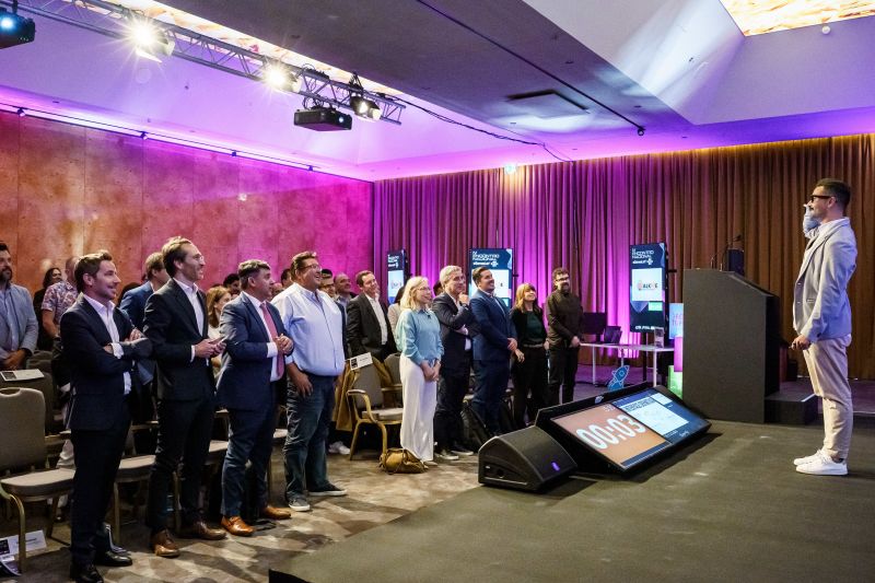Presentation on stage at the IV eGames Lab National Meeting, with the audience standing to watch